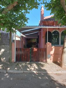 uma casa com um portão de madeira em frente em Beach House São Pedro em São Pedro do Estoril