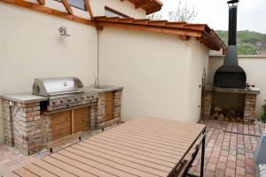 a patio with a grill and an outdoor oven at Bodrogpart Vendégház Tokaj in Tokaj