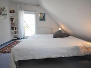 a bedroom with a white bed and a window at Ferienhaus Lütt Matten in Wustrow