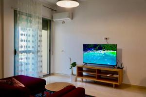 ein Wohnzimmer mit einem Flachbild-TV auf einem Stand in der Unterkunft Lovely 2 bedroom condo with free parking in Vlorë