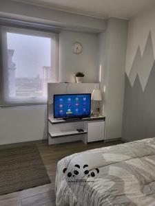 a bedroom with a flat screen tv and a bed at Apartment Kalibata City by PanBul in Jakarta