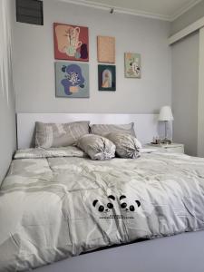 a bedroom with a bed with panda pillows on it at Apartment Kalibata City by PanBul in Jakarta