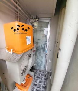 a shower with an orange box on the back of it at Apartment Kalibata City by PanBul in Jakarta