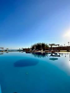 una grande piscina di acqua blu con edifici sullo sfondo di Nautica Hotel Apartments a Stavromenos