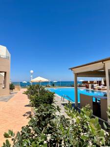 a resort with a swimming pool and tables and chairs at Nautica Hotel Apartments in Stavromenos