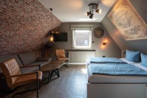 a bedroom with a bed and a couch and a table at Hotel Luina Beach in Büsum