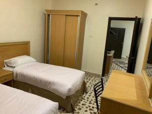 a hotel room with two beds and a mirror at Madaba Mesha Stele Bedoiun Apartments in Madaba