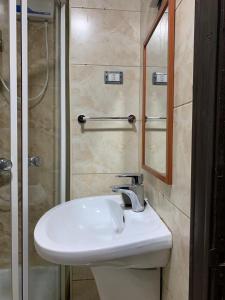 a bathroom with a sink and a shower and a mirror at Madaba Mesha Stele Bedoiun Apartments in Madaba