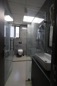 a bathroom with a sink and a toilet and a mirror at The White Lotus in Gaya