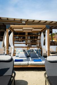 ein Bett unter einem Pavillon auf einer Terrasse in der Unterkunft Skiathos Thalassa Cape, Philian Hotels and Resorts in Megali Ammos