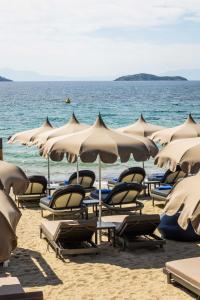 un gruppo di sedie e ombrelloni in spiaggia di Skiathos Thalassa Cape, Philian Hotels and Resorts a Megali Ammos