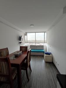 un soggiorno con tavolo, sedie e divano di Apartamento embajada americana a Bogotá