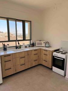 uma cozinha com um fogão e um micro-ondas em Starlight: A desert unit em Niẕẕane Sinay