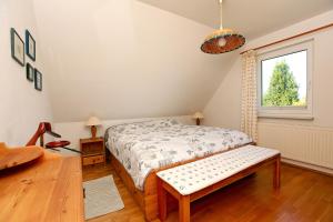 Schlafzimmer mit einem Bett und einem Fenster in der Unterkunft Ferienhaus Uli in Wustrow