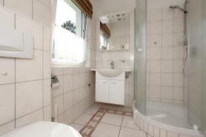 y baño con aseo, lavabo y ducha. en Ferienhaus Uli, en Wustrow