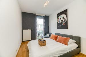 una camera da letto con un letto con lenzuola bianche e cuscini arancioni di Le Bali- Garage- Terrasse- Relaxant- Belle Vue a Grenoble