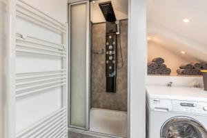 kabina prysznicowa w pralni z pralką i suszarką w obiekcie Dück w mieście Stühlingen
