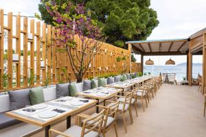 メガリ・アモスにあるSkiathos Thalassa Cape, Philian Hotels and Resortsのパティオ(テーブルと椅子付)