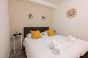 a bedroom with a white bed with towels on it at La Chatelaine in Egmond aan Zee