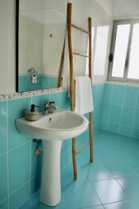 ein blaues Badezimmer mit einem Waschbecken und einem Spiegel in der Unterkunft Lovely 2 bedroom condo with free parking in Vlorë