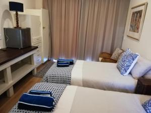 Habitación de hotel con 2 camas y TV en Barnard Self-Catering Apartments, en St Francis Bay