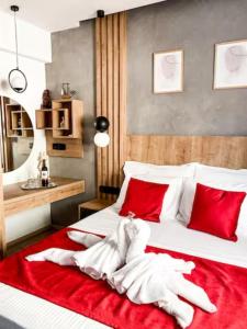 Magdalena Suite 1,0 في مدينة هيراكيلون: غرفة نوم مع سرير أبيض كبير مع وسائد حمراء