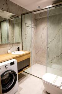 Un baño con lavadora y un inodoro. en Magdalena Suite 1,0, en Heraclión