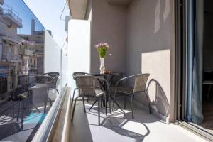 a balcony with chairs and a table with a vase of flowers at Magdalena Suite 1,0 in Heraklio