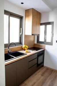 una cocina con fregadero y fruta en la barra en Magdalena Suite 1,0, en Heraclión 8 fotos más