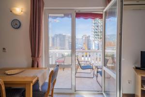 a room with a table and a view of a balcony at Villa Maxima Budva in Budva