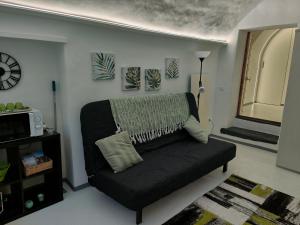 ein Wohnzimmer mit einem Sofa und einer Uhr an der Wand in der Unterkunft Appartamento Ca' Sistina Green a Morcote in Morcote