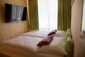 um quarto com uma cama com almofadas e uma televisão em Bosruck Chalet em Misselsdorf