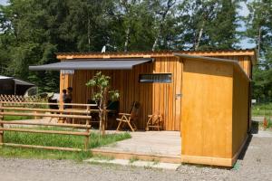 a small wooden shed with a man standing in front of it at Bosruck Chalet in Misselsdorf