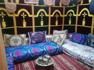 Habitación con almohadas coloridas y sofá. en Al Andaloussiya Diyafa en Moulay Idriss