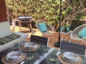 a patio with a table and chairs and a piano at Bungalow Tunos Maspalomas in San Bartolomé
