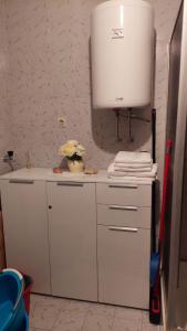 a white kitchen with a white tank and towels at Apartments Branko in Veli Rat