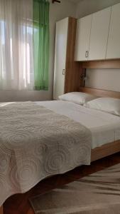 - une chambre avec 2 lits et un rideau vert dans l'établissement Apartments Branko, à Veli Rat