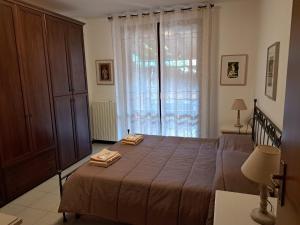 a bedroom with a bed and a large window at Casa vacanze Monterenzio Bologna in Monterenzio