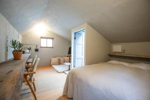 um quarto com uma cama e uma mesa num quarto em LOOF Tiny House Camp em Fuefuki
