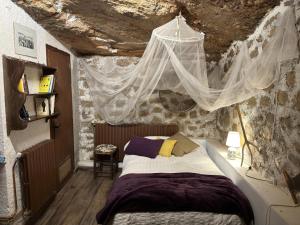 a bedroom with a bed in a stone wall at CASA NOTARI - Casa Rural Zona Congost de Montrebei in Tolva