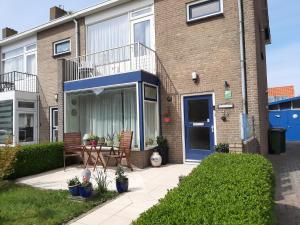 a house with a patio with a table and chairs at Logies Plevierstraat in De Koog
