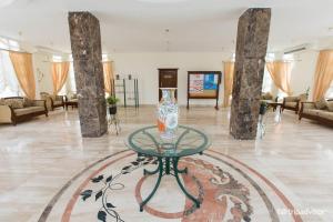 Halomy Sharm Resort في شرم الشيخ: وجود مزهرية على طاولة زجاجية في بهو الفندق