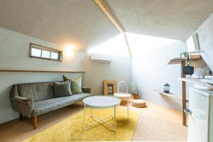 uma sala de estar com um sofá e uma mesa em LOOF Tiny House Camp em Fuefuki