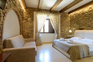 B&B Le Stanze di Ludovica في تيرمولي: غرفة نوم بسريرين وجدار حجري