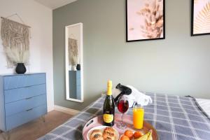 ein Tablett mit Essen und Wein auf dem Bett in der Unterkunft Grange House with Free Parking, Garden, Superfast Wifi and Smart TVs with Netflix by Yoko Property in Northampton