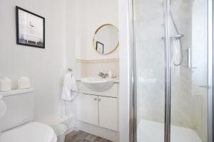 a bathroom with a shower and a toilet and a sink at Grange House with Free Parking, Garden, Superfast Wifi and Smart TVs with Netflix by Yoko Property in Northampton