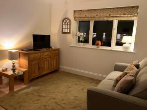 uma sala de estar com um sofá e uma televisão de ecrã plano em HomeForYou - Holiday Home in the Wolds em Spilsby