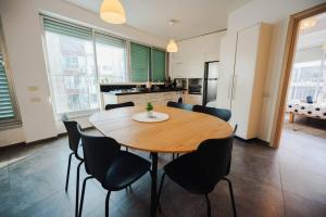 een keuken met een houten tafel en zwarte stoelen bij spacious apartment in Tel Aviv