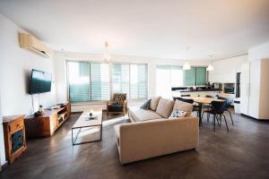 een grote woonkamer met een bank en een tafel bij spacious apartment in Tel Aviv