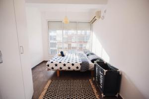 een kleine kamer met een bed in een kamer met een raam bij spacious apartment in Tel Aviv
